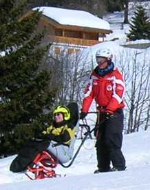 Der Skilehrer Simon f&uuml;hrt Angela sicher auf der Piste